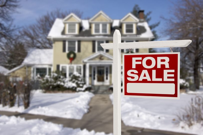 24766407 l home for sale real estate sign in front of beautiful new house in the snow 810x538